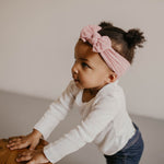 Pink cable knit knotted headband for baby girl.