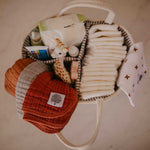 Muslin burp cloths in diaper caddy.