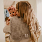 Gray burp cloth for mom's shoulder.