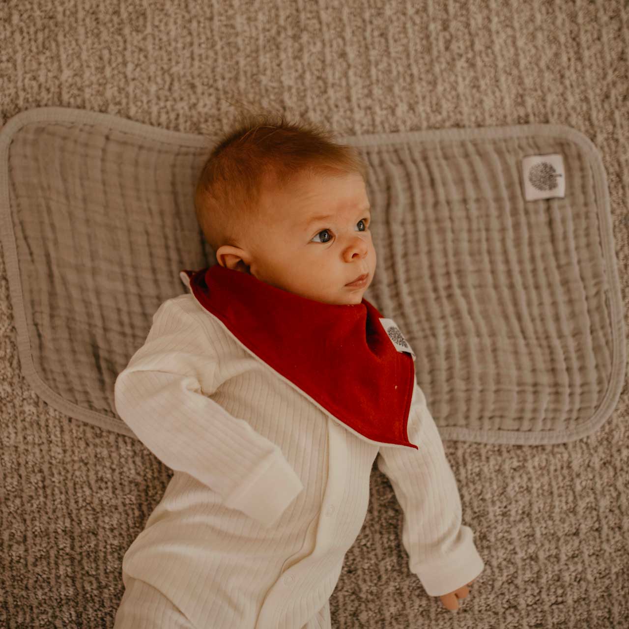 Gray burp cloth for baby to lay on.