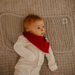 Gray burp cloth for baby to lay on.