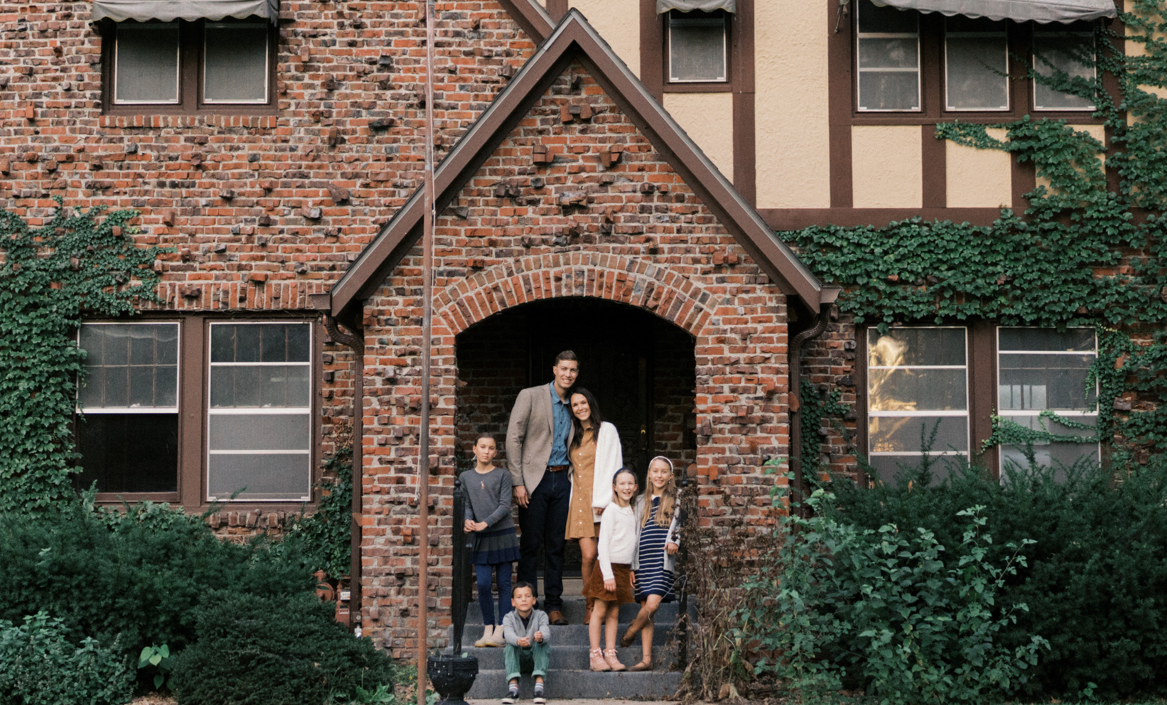 Family standing together outside their new home after moving and starting a new chapter.
