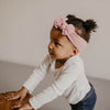 Pink cable knit knotted headband for baby girl.