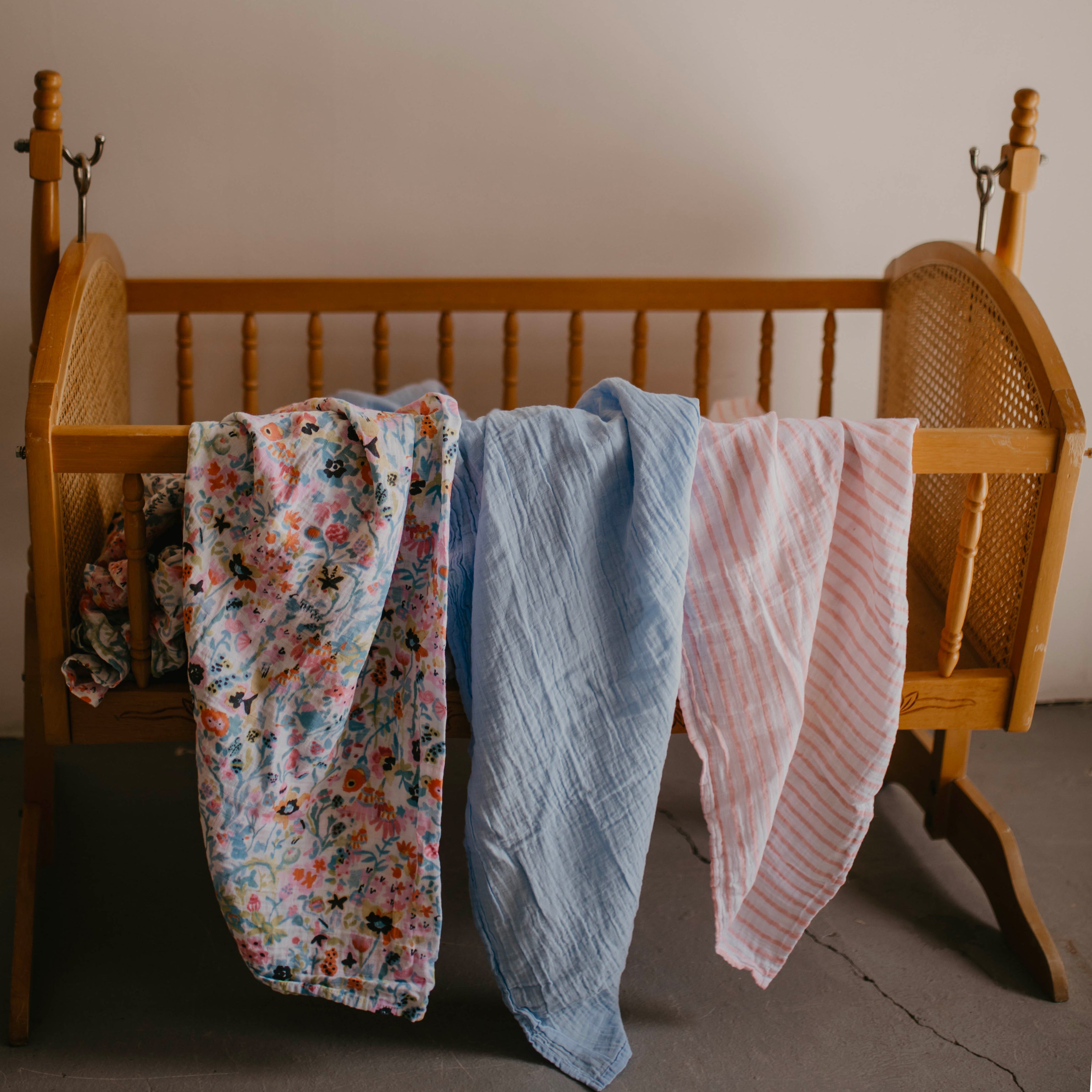 Blossom Swaddle Set draped on Crib. 