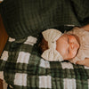 Green buffalo quilt for baby to lay on.