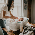 Baby in bathtub with washcloth